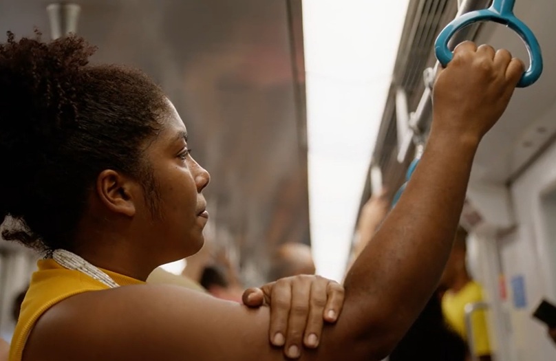 women standing on train holding on to support